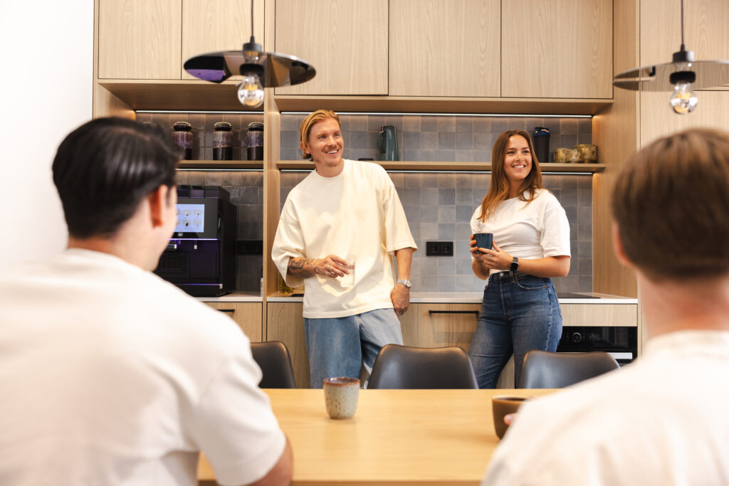 4 collega's met elkaar in gesprek in een keuken.